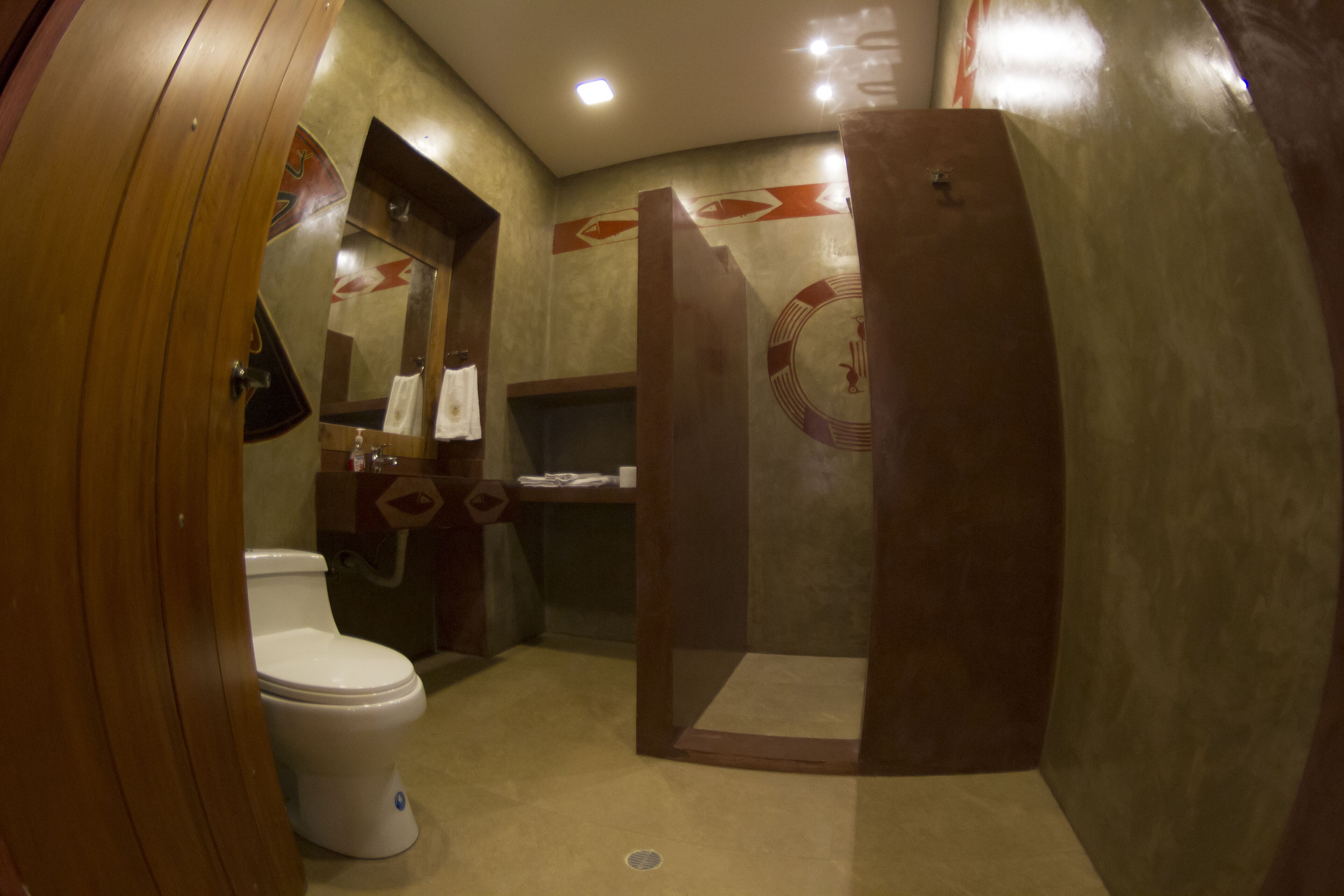 A bathroom with a toilet, a sink, and a shower area.