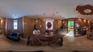 Un amplio salón con sofá, sillones, una mesa de centro y una recepción.