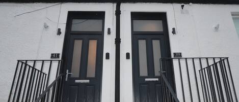 A building with two black doors, each marked with a number.