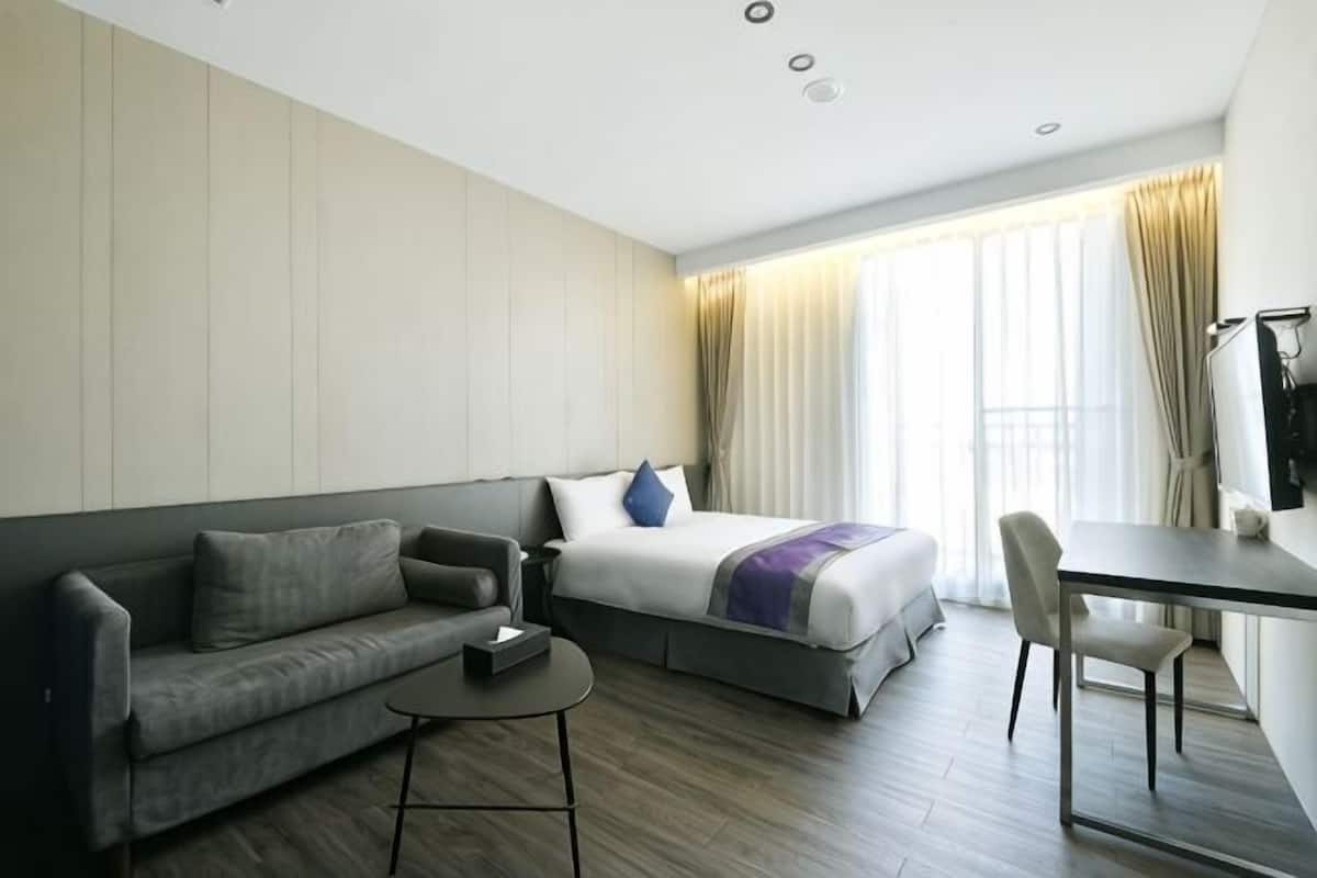 Une chambre dâhĂŽtel avec un lit, un canapĂ©, un bureau et une chaise.