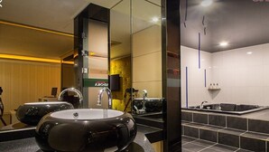 A modern bathroom with a large mirror, two sinks, a bathtub, and a vanity area. - Madoka (Gyeongju)