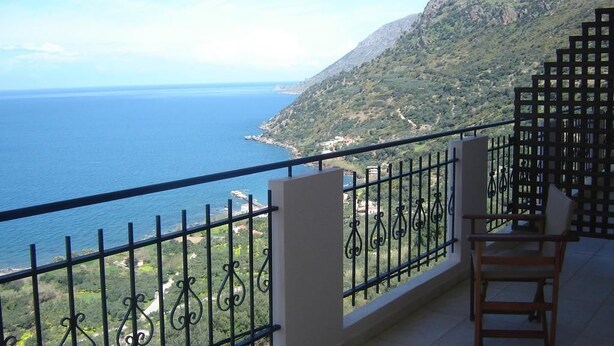 A balcony with a view of the sea and a mountainous landscape. - Kleio Studios (Platanias)