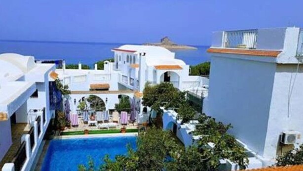 Un edificio blanco con piscina y vistas al mar.