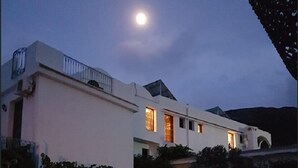Un edificio moderno con fachada blanca, varias ventanas y un balcón.