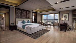 Ein modernes Hotelzimmer mit einem großen Bett, einem Schreibtisch und Blick auf die Stadt.