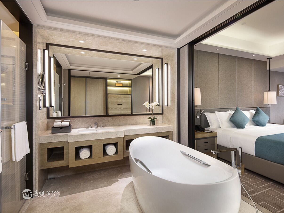 A modern bathroom with a large bathtub, a double sink vanity, and a large mirror.