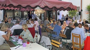 An outdoor dining area with tables and chairs under a large canopy. - Hotel zur Post (Hünfelden)