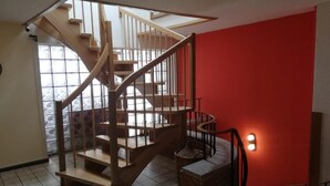A wooden spiral staircase with a glass balustrade, leading to an upper floor. - Hotel zur Post (Hünfelden)