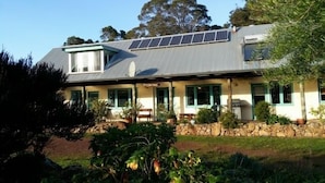Ein zweistöckiges Haus mit geneigtem Dach, Solaranlage und einem Stein Fundament.