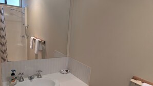 A bathroom with a white sink, a mirror, a towel rack, and a shower door. - Riverside Golf Club 3 Bedroom Holiday House (Nichols Point)