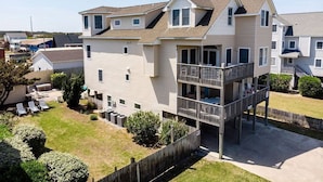 A two-story residential building with a balcony on the second floor. - Cloud Nine - KDH MP 7, Semi-Oceanfront, Ocean View, 120 Yds to Beach, Pool, Hot Tub, Pets OK (Kill Devil Hills)
