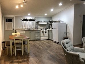 Enjoy meals in this kitchen with an oven, refrigerator, and sink, plus a dining table and chairs.