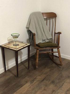 Relax in a cozy corner with a comfortable rocking chair and a small table.