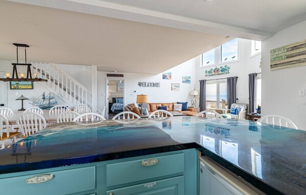 A spacious living area with a large pool, a staircase, and a 'WELCOME' sign.