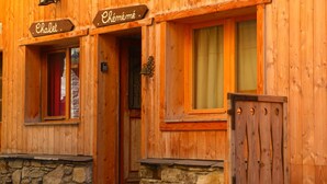 Ein hölzernes Gebäude mit Schildern, auf denen „Chalet“ und „Chémé“ steht.