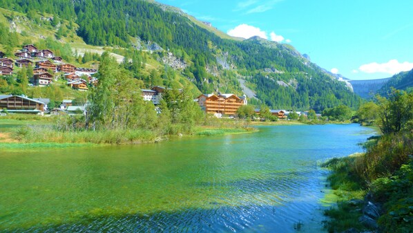 A river flowing through a mountainous area with houses on the banks.