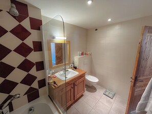 A bathroom with a checkered floor, a wooden vanity, a sink, a mirror, a toilet, and a shower area. - Apartment/ flat - Meribel (Les Allues)