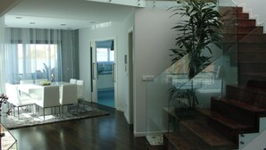 Ein modernes Interieur mit Essbereich, Treppe und Blick in die Küche.