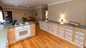 A kitchen with wooden cabinets, a stove, and a countertop. - Lamp Post Lodge (Westcliffe)