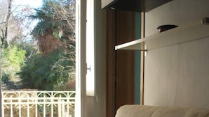 A beige sofa in a room with a white railing and a view of greenery outside. - CHARME AND RELAX HISTORIC HOUSE ON THE HILL (Torino)