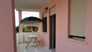 A covered outdoor area with a picnic table and umbrella, a tiled floor, and a pink wall. - Apartment/ flat - POSADA (Posada)