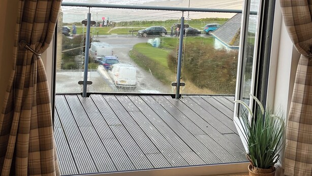 A balcony with a view of the sea and a parking area. - Magnificent Sea views, Central, 2 double bedrooms, 2 bathroom. Pets welcome.   (Newquay)