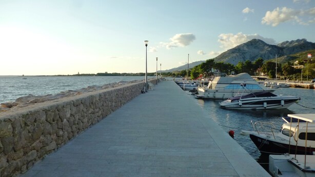A marina with boats docked, a stone wall, and a paved walkway leading to the water. - Mareta apartment with free wifi in a stone house (Seline)