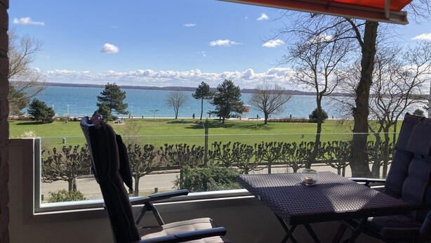 Un balcón con vista a un lago y un área verde.