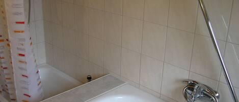 A bathroom with a bathtub, a shower, and a toilet.