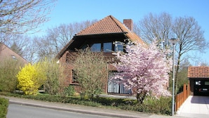 A two-story house with a brick facade and a tiled roof.