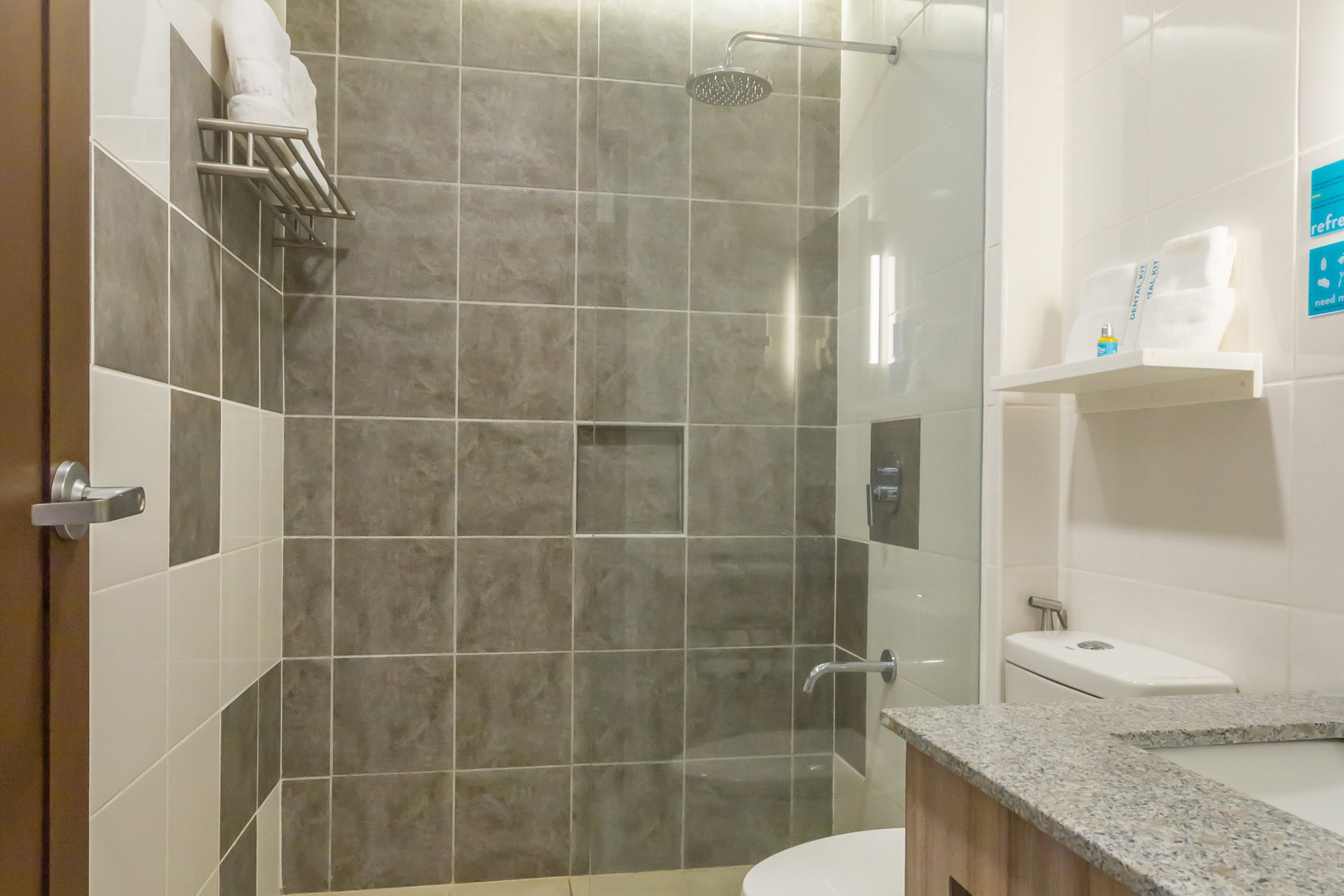 A modern bathroom with a shower, toilet, and sink.