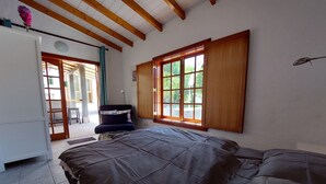 A bedroom with a bed, a chair, a wardrobe, and a window with a view of greenery. - 🦎Charming gem with pool in the mountains. Located 20min sw. from Las Palmas 🦎 (santa brigida)