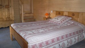 Una camera in una baita di legno con un letto, un comodino e una scala.