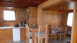 Cucina in legno con un'area pranzo, pensili in legno e una lavastoviglie.