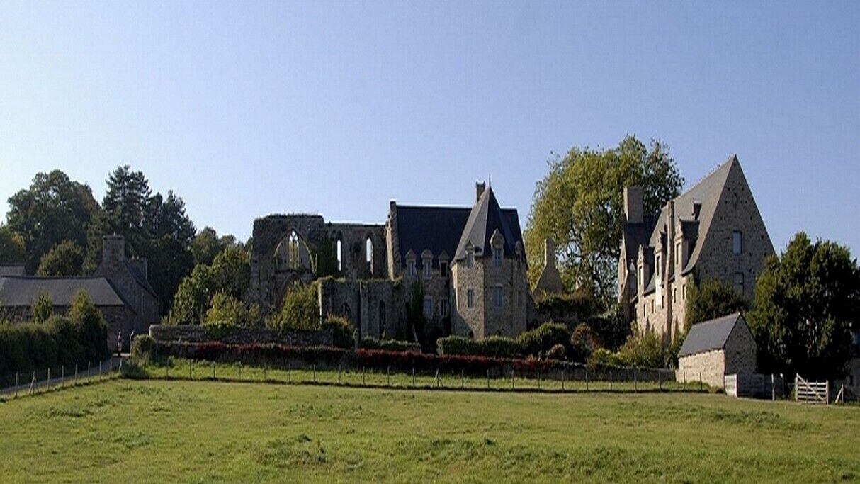 A historic stone building with arched windows and a prominent tower.