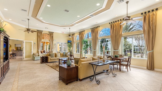 A spacious living room with a large sofa, a coffee table, and a dining area with chairs and a table.
