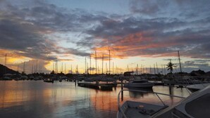 A marina at sunset with multiple boats docked.