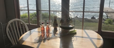 Enjoy a romantic meal for two by the sea with a table set for a serene dining experience.