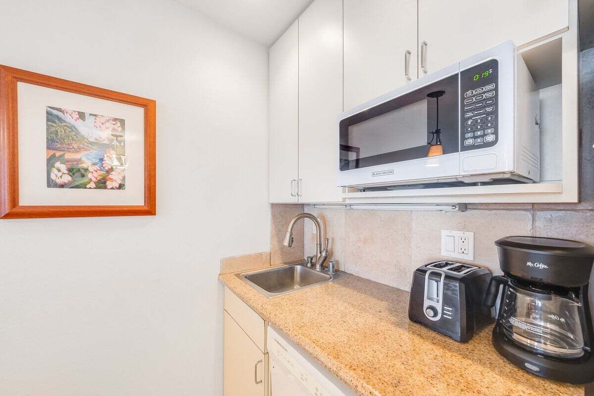 A kitchen with a microwave, toaster, and coffee maker on the countertop.