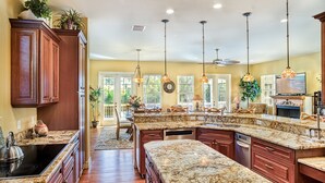A spacious kitchen with granite countertops, wooden cabinets, and pendant lighting. -  FREE golfcart and bicycles, Perfect location, 5 star reviews, beautiful home ! (captiva island)