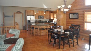 Una cocina amplia con armarios de madera, una isla central y un comedor con sillas y una mesa.