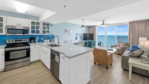 A modern kitchen with white cabinets, a stainless steel oven, and a built-in microwave.