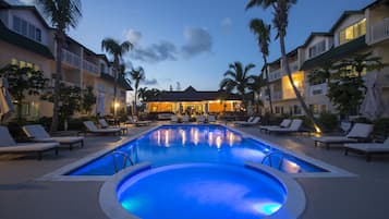 Una piscina al aire libre, sillones reclinables de piscina