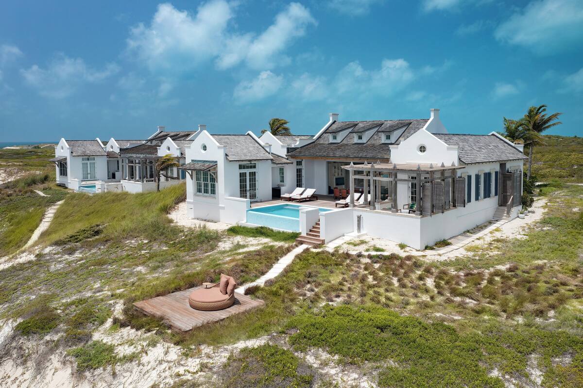 A coastal house with a swimming pool, multiple rooms, and a deck area.