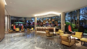 A spacious lobby with a bar area, seating arrangements, and large windows offering views of the cityscape. - Hilton Garden Inn Sanya (Sanya)