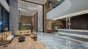 A spacious lobby with a curved seating area, a staircase, and a reception desk. - Hilton Garden Inn Sanya (Sanya)