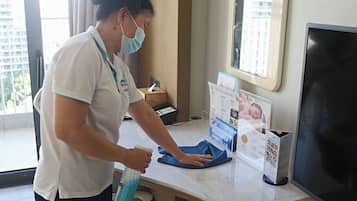 A person cleaning a counter in a room with a window, a tissue box, and a magazine rack.