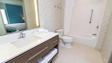 A modern bathroom with a double sink vanity, a toilet, and a walk-in shower.