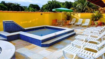Relax by the pool with a hot tub and lounge chairs.