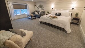 A bedroom with a large bed, a sofa, a small table, and a window with curtains. - The Barn at Strasburg B&B (Strasburg)